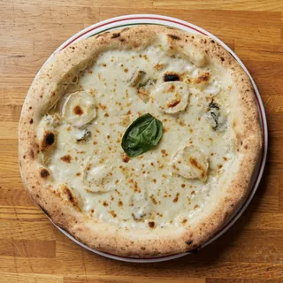 La 4 Formaggi vue du dessus : chèvre, gorgonzola et une feuille de basilic